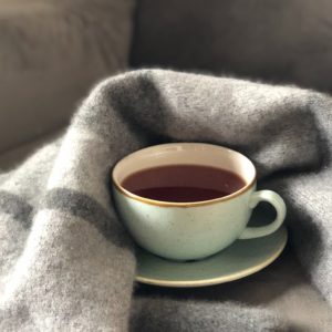 Tasse de thé et couverture suggérant le réconfort